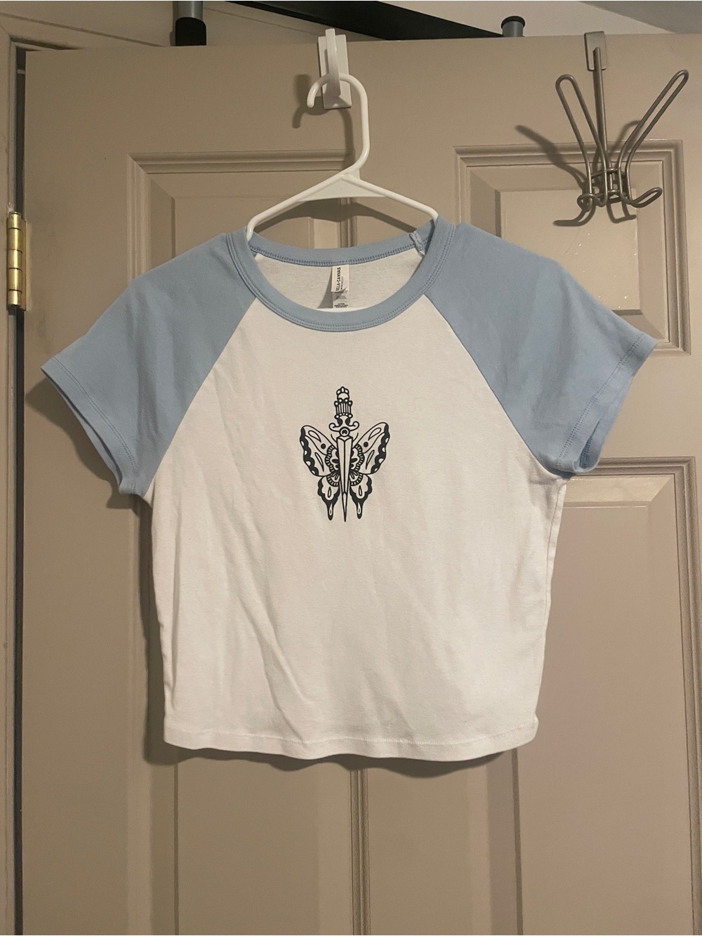 White Baby Tee with Blue Sleeves and Traditional Tattoo Design Graphic